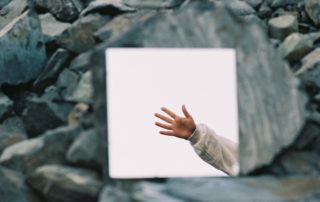 a person reaching out their hand to catch a frisbee